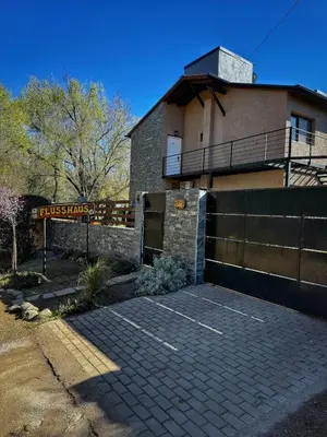 a house with a brick parking lot in front of it at Flusshaus8 in Villa General Belgrano