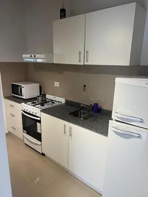 a kitchen with a stove and a sink and a refrigerator at Flusshaus8 in Villa General Belgrano