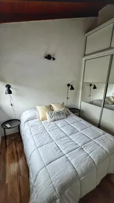 a bedroom with a large white bed with two lamps at Flusshaus8 in Villa General Belgrano