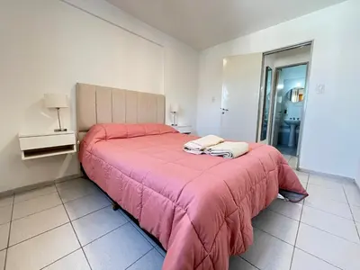 a bedroom with a bed with a pink blanket at Departamento comodo y central en Córdoba, a metros de la Cañada in Cordoba