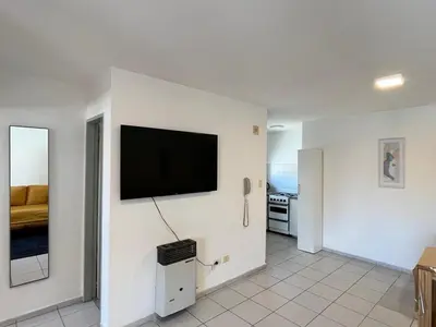 a living room with a flat screen tv on a wall at Departamento comodo y central en Córdoba, a metros de la Cañada in Cordoba