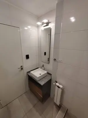 a white bathroom with a sink and a mirror at Atp Bolivia 164 in Cordoba