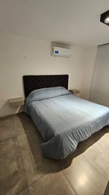 a bedroom with a large bed with blue sheets at Atp Bolivia 164 in Cordoba