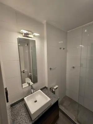 a white bathroom with a sink and a mirror at Atp Bolivia 164 in Cordoba