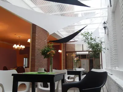 a restaurant with tables and chairs and a ceiling at Santiago Hotel in Cordoba