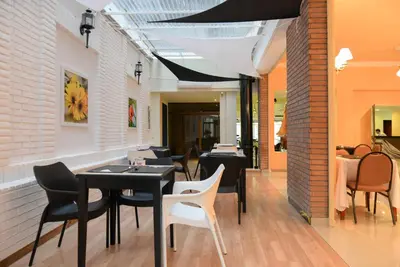 a restaurant with black tables and white chairs at Santiago Hotel in Cordoba