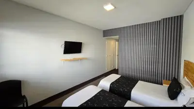 a hotel room with two beds and a television at Santiago Hotel in Cordoba