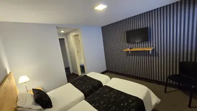 a hotel room with a bed and a flat screen tv at Santiago Hotel in Cordoba