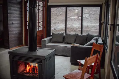 a living room with a fireplace and a couch at Cabaña en Tala Cruz a 9km de Villa Cañada del Sauce in Tala Cruz