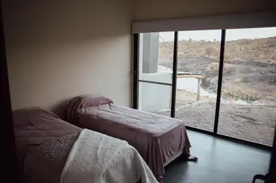 a bedroom with two beds and a large window at Cabaña en Tala Cruz a 9km de Villa Cañada del Sauce in Tala Cruz