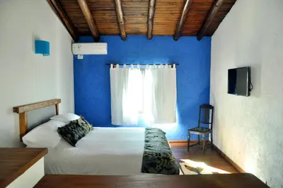 a blue bedroom with a bed and a window at Senderos del Tao in Las Rabonas