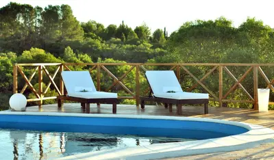 two white chairs sitting next to a swimming pool at Senderos del Tao in Las Rabonas