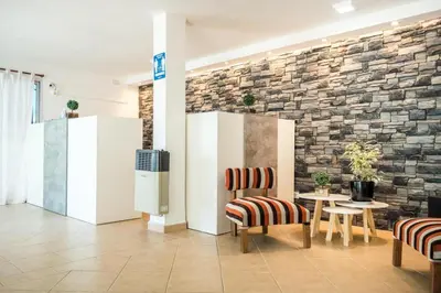 a room with chairs and a table and a brick wall at Hotel Posada del Ángel in Villa Carlos Paz