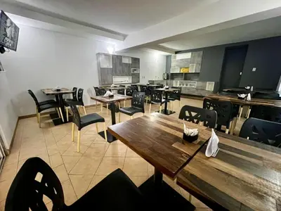 an empty restaurant with wooden tables and chairs at Hotel Posada del Ángel in Villa Carlos Paz