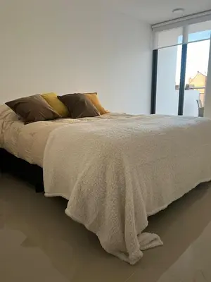 a bed with a blanket on it with a window at Calasanz Premium in Cordoba