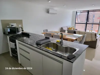 a kitchen with a sink and a living room at Calasanz Premium in Cordoba