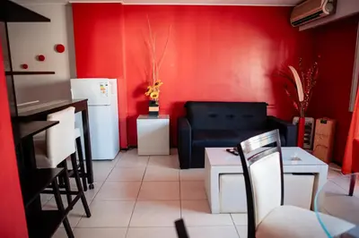 a living room with red walls and a black couch at Dpto 1 hab con cochera in Cordoba