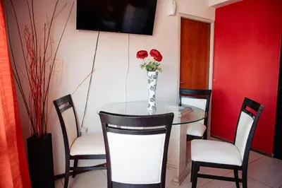 a dining room table with a vase of roses on it at Dpto 1 hab con cochera in Cordoba