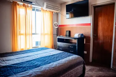 a bedroom with a bed and a television and a window at Dpto 1 hab con cochera in Cordoba