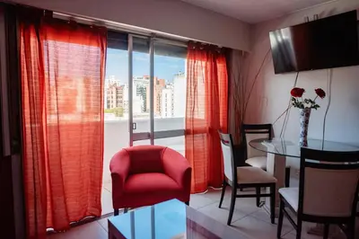 a living room with a red chair and a table at Dpto 1 hab con cochera in Cordoba