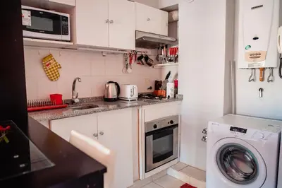 a kitchen with a washing machine and a washer at Dpto 1 hab con cochera in Cordoba