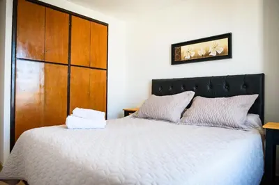 a bedroom with a large bed with a wooden headboard at Dpto 1 habitación con cochera in Cordoba