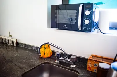 a kitchen counter with a sink and a microwave at Dpto 1 habitación con cochera in Cordoba
