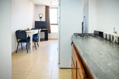 a kitchen and dining room with a table and a counter at Dpto 1 habitación con cochera in Cordoba