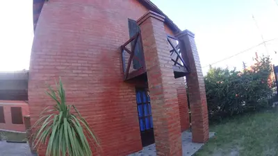 a red brick building with two windows and a plant at Cabañas Rosarito in Villa Larca