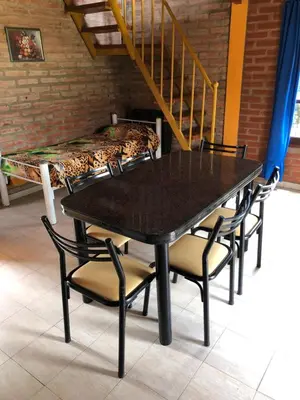 a table and chairs with beds in a room at Cabañas Rosarito in Villa Larca