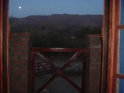 an open door with a view of the moon at Cabañas Rosarito in Villa Larca