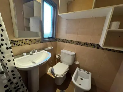 a bathroom with a white toilet and a sink at Departamento Céntrico in Cordoba