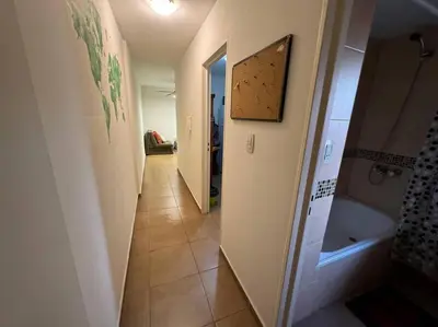 a hallway of a bathroom with a sink and a tub at Departamento Céntrico in Cordoba