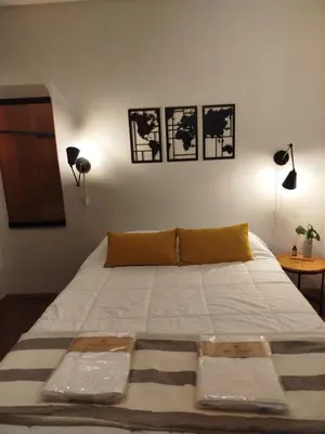 a bed in a bedroom with three pictures on the wall at Funes Departamento céntrico un dormitorio Solo turistas in Cordoba