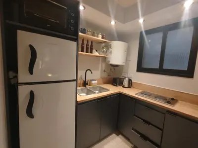 a small kitchen with a refrigerator and a sink at Funes Departamento céntrico un dormitorio Solo turistas in Cordoba