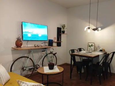 a living room with a tv and a table with a bike at Funes Departamento céntrico un dormitorio Solo turistas in Cordoba