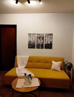 a living room with a yellow couch and a table at Funes Departamento céntrico un dormitorio Solo turistas in Cordoba