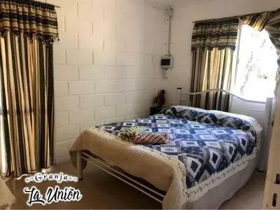 a bedroom with a bed in a room with a window at Granja La Unión in Villa Dolores