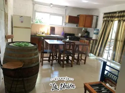 a kitchen and dining room with a table and a barrel at Granja La Unión in Villa Dolores