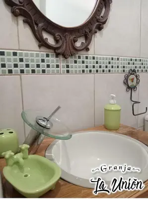 a bathroom with a sink and a mirror and a tub at Granja La Unión in Villa Dolores