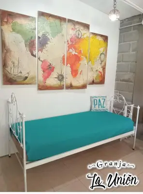 a bed in a room with four paintings on the wall at Granja La Unión in Villa Dolores