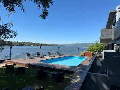 a swimming pool with a view of the water at Ciervo de Oro in Villa Carlos Paz