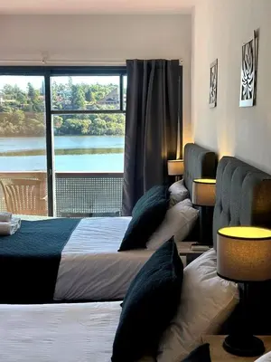 a bedroom with two beds and a large window at Ciervo de Oro in Villa Carlos Paz