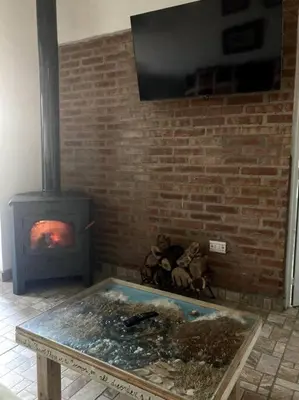 a room with a fireplace and a stove at Casita Sirio in Mina Clavero