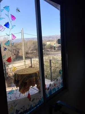 a window with a view of a table on a balcony at Casita Sirio in Mina Clavero