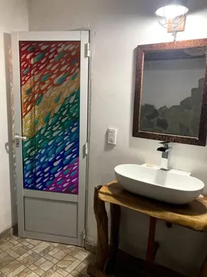 a bathroom with a sink and a painting on the wall at Casita Sirio in Mina Clavero