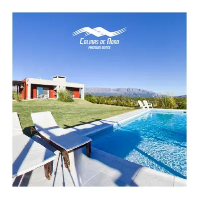 a villa with a swimming pool and a house at Colinas de Nono in Nono