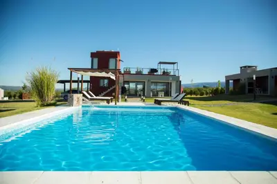 a swimming pool with a house in the background at Colinas de Nono in Nono