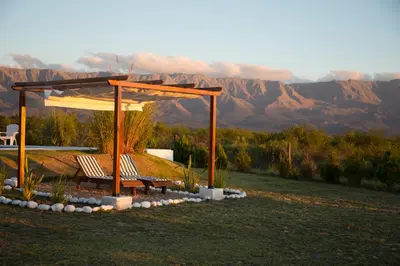 a bench under a gazebo with mountains in the background at Colinas de Nono in Nono