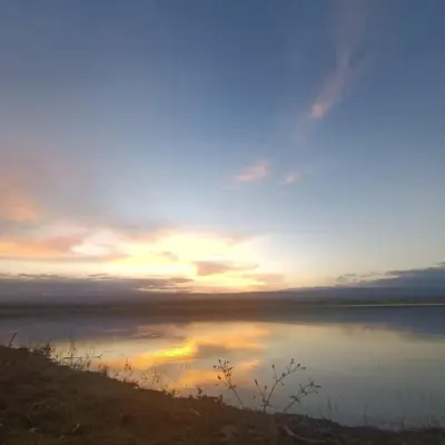 a sunset over a body of water at Tiny Samay Punto Claro in Villa Ciudad Parque